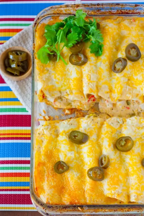 An overhead shot of Creamy White Sauce and Crab Enchiladas topped with jalapenos