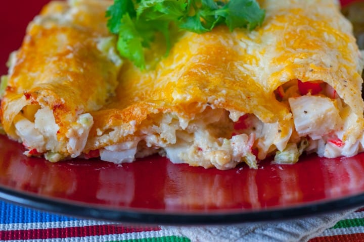A close up of Creamy White Sauce and Crab Enchiladas on a plate