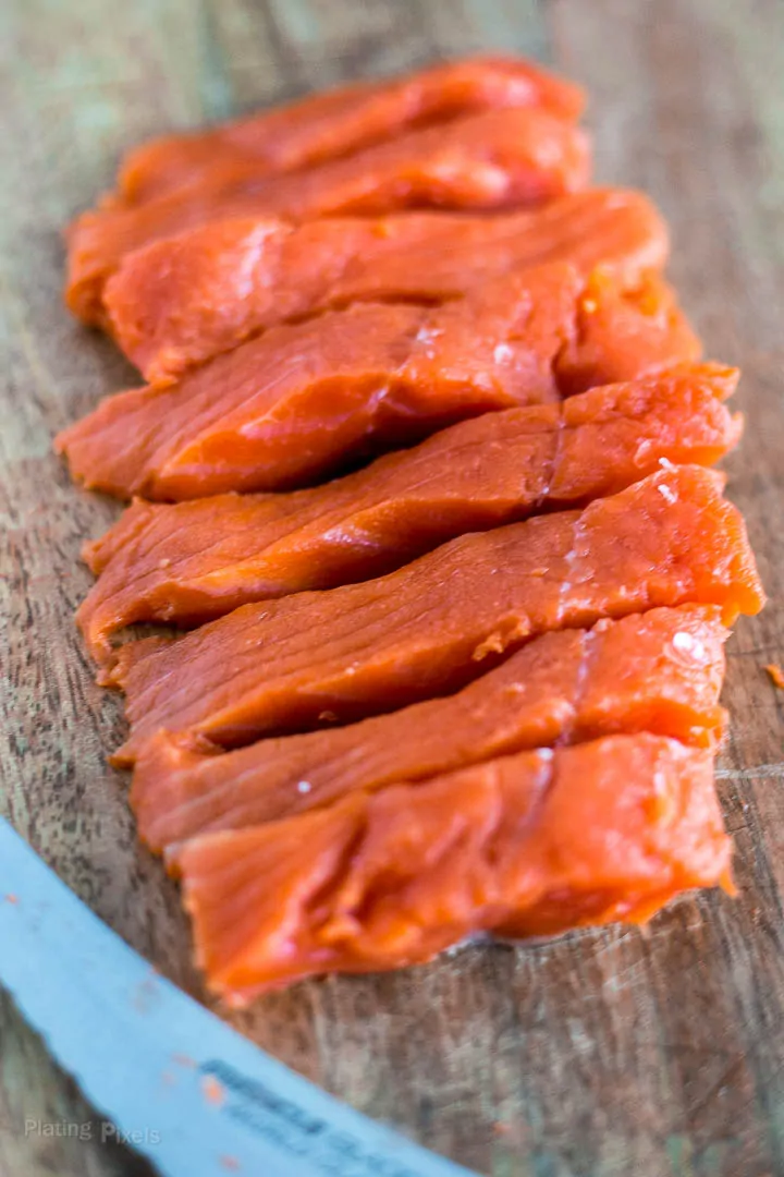 Slices of salmon a a cutting board to make kabobs
