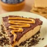 A slice of Fudgy Chocolate Peanut Butter Cheesecake on a white plate
