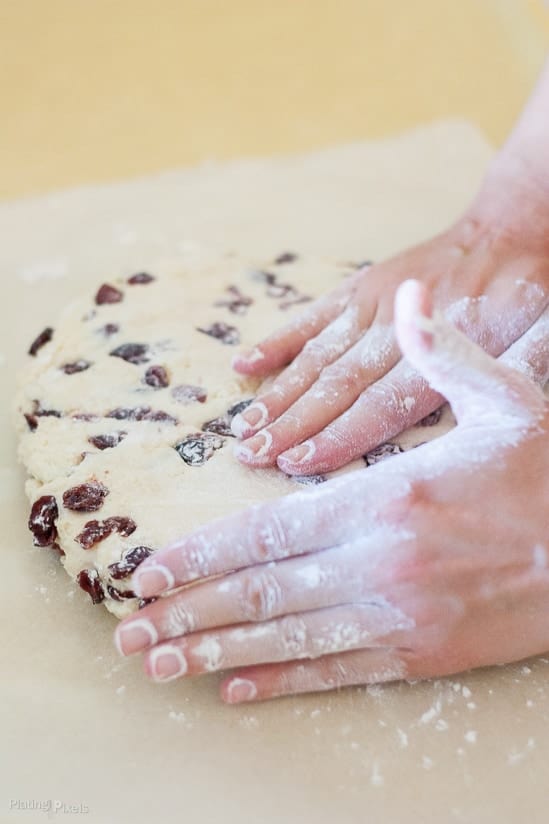 Two hands kneading white chocolate cranberry scones