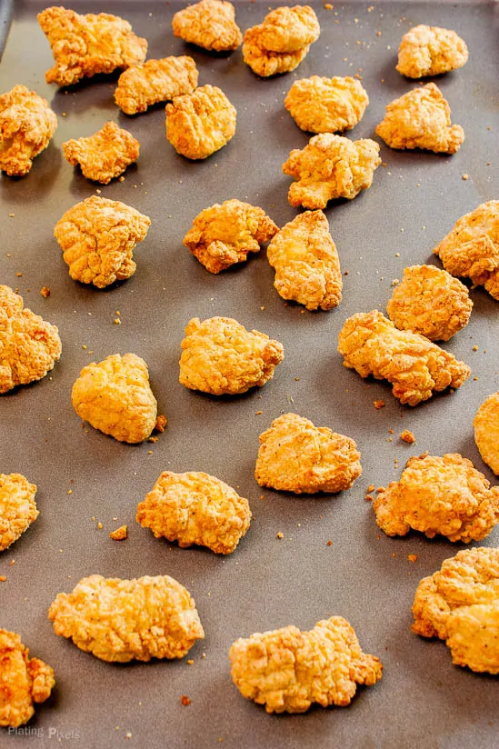 Just baked breaded chicken nuggets on a baking sheet