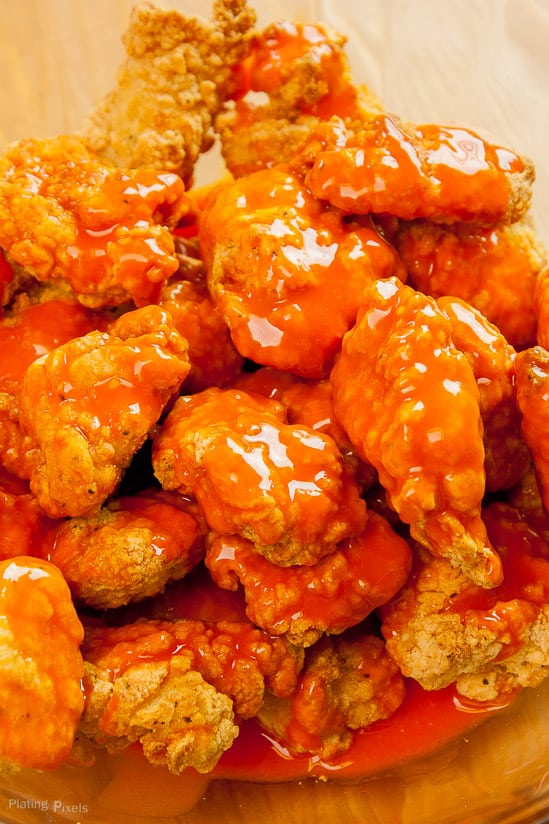 Close up of beaded chicken tossed with buffalo sauce