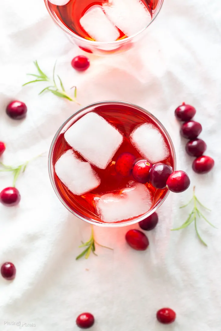An overhead shot of an Apple Cranberry Ginger Ale Spritzer garnished with fresh cranberries