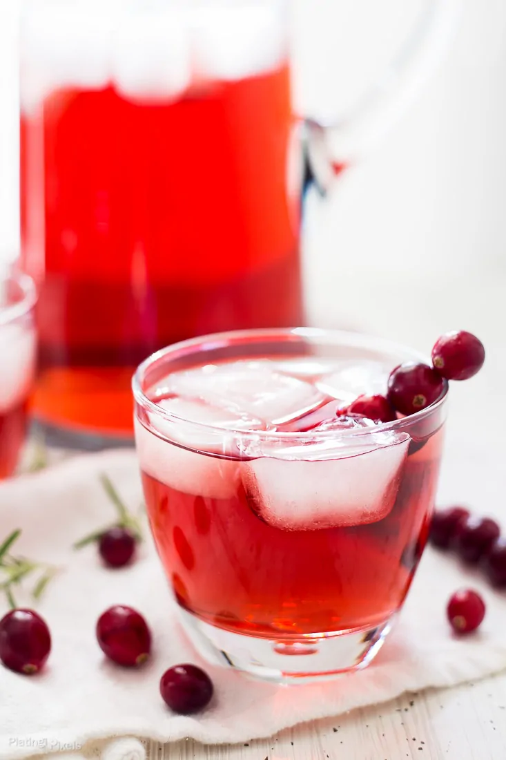 A close up of an Apple Cranberry Ginger Ale Spritzer in a small glass with ice