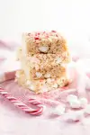Three stacked Brown Butter Peppermint Rice Krispie Treats with candy cane decorations
