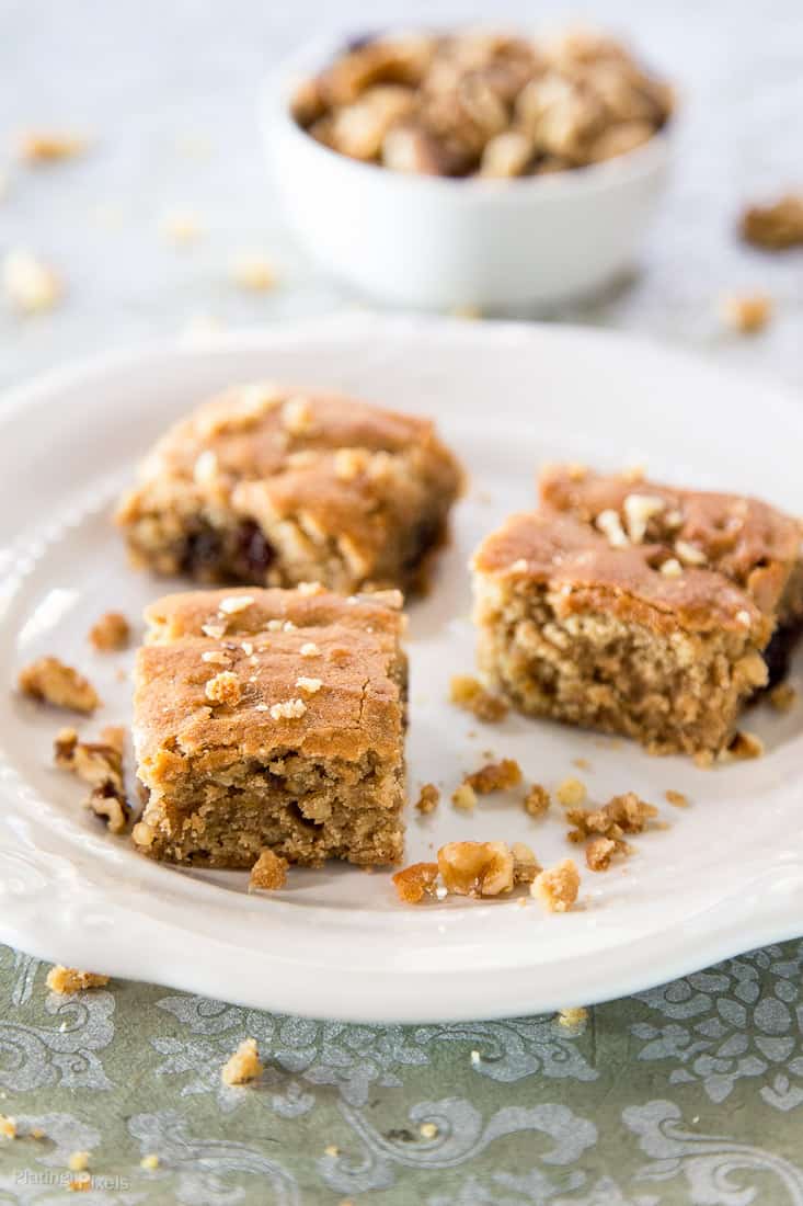 Three Cranberry Maple Blondies sitting on a white plate