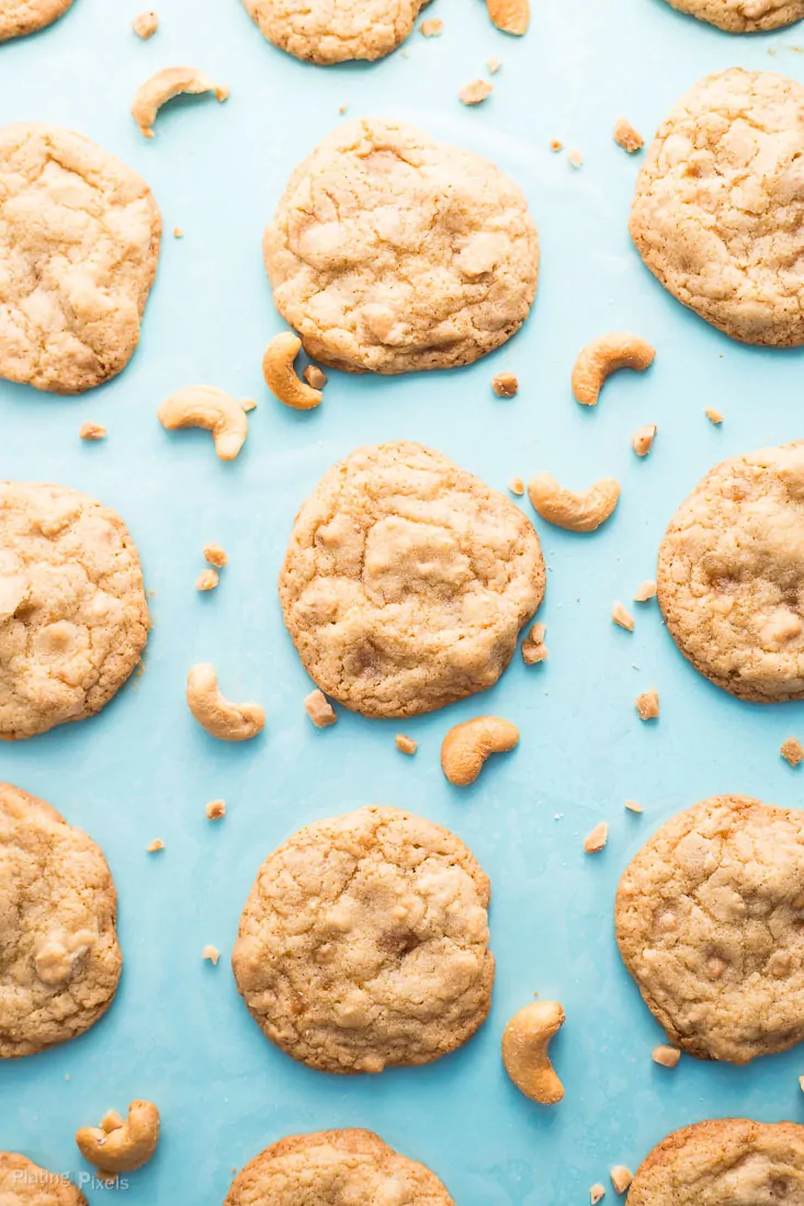 Baked Chewy Cashew Toffee Cookies on a teal cookie sheet