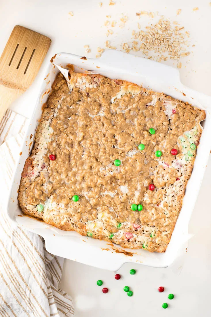 Chewy Coconut Chocolate Oatmeal Bars in a white square dish topped with red and green m&m's
