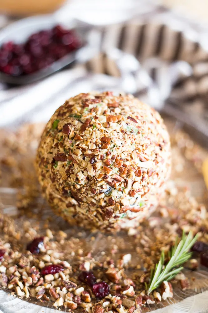 A close up of Craisins White Cheddar Cheese Ball covered in pecans