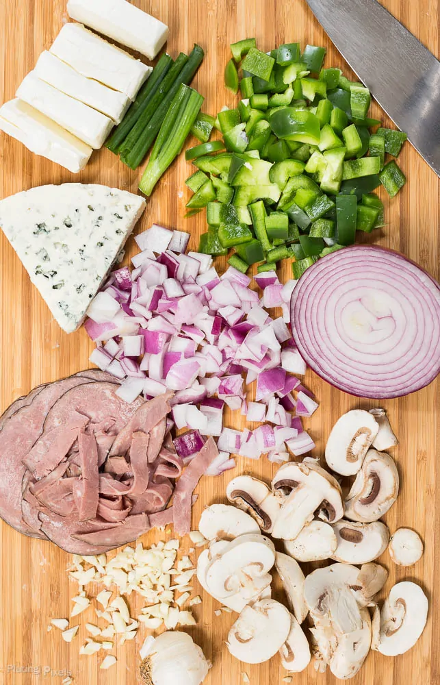 Ingredients on a board for making a Philly Cheese Steak Dip
