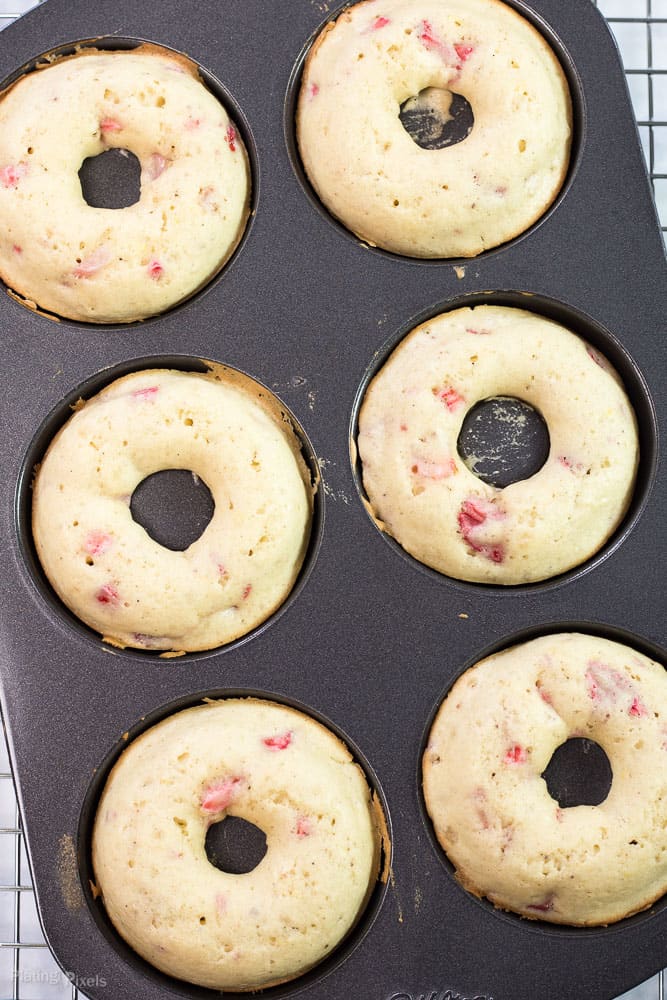 Process shot of six just baked doughnuts in a doughnut pan