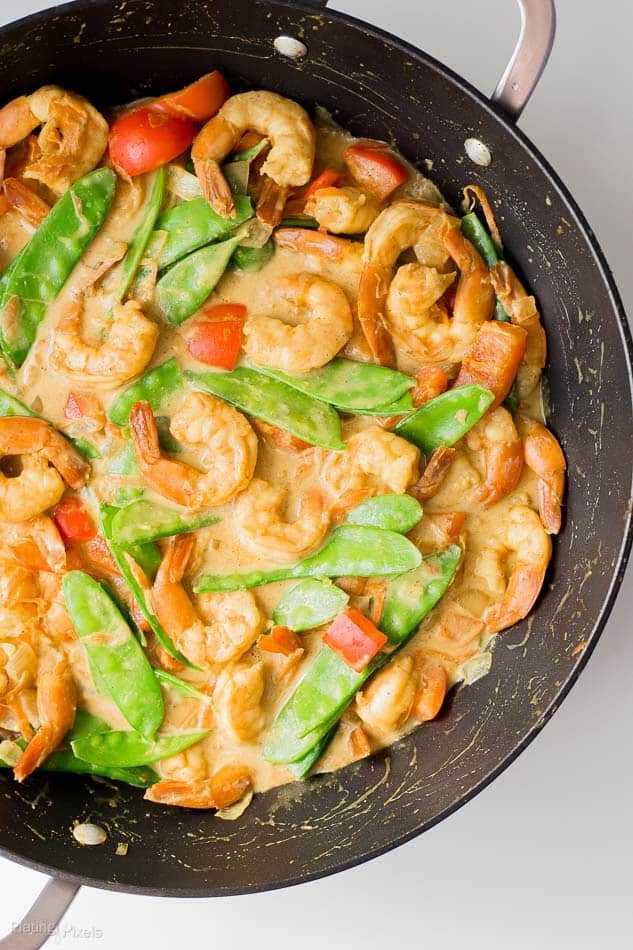 Coconut Curry Shrimp in a wok cooking with vegetables