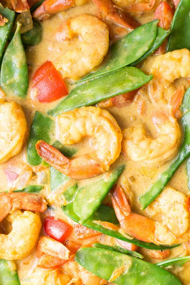 A process shot of Coconut Curry Shrimp with snow peas and bell peppers cooking in a wok
