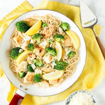 Lemon Broccoli Chicken Pasta in a skillet pan with a yellow dish cloth underneath