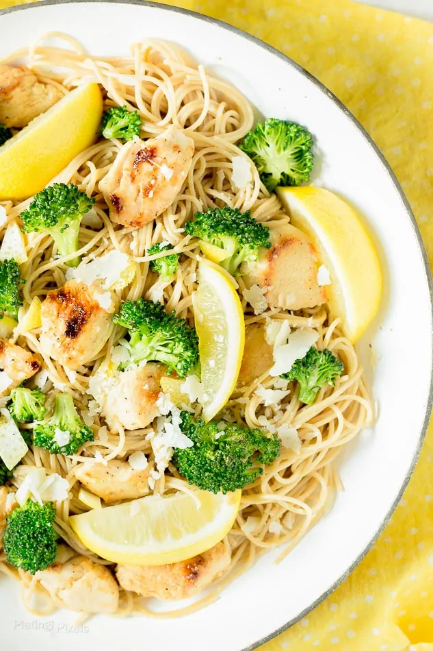 A close up of Lemon Chicken Pasta mixed together with broccoli on a white plate