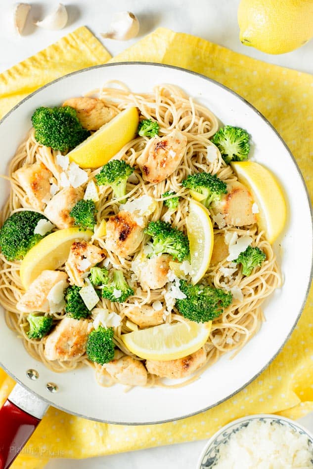  Lemon Broccoli Chicken Pasta in a white pan garnished with lemon wedges