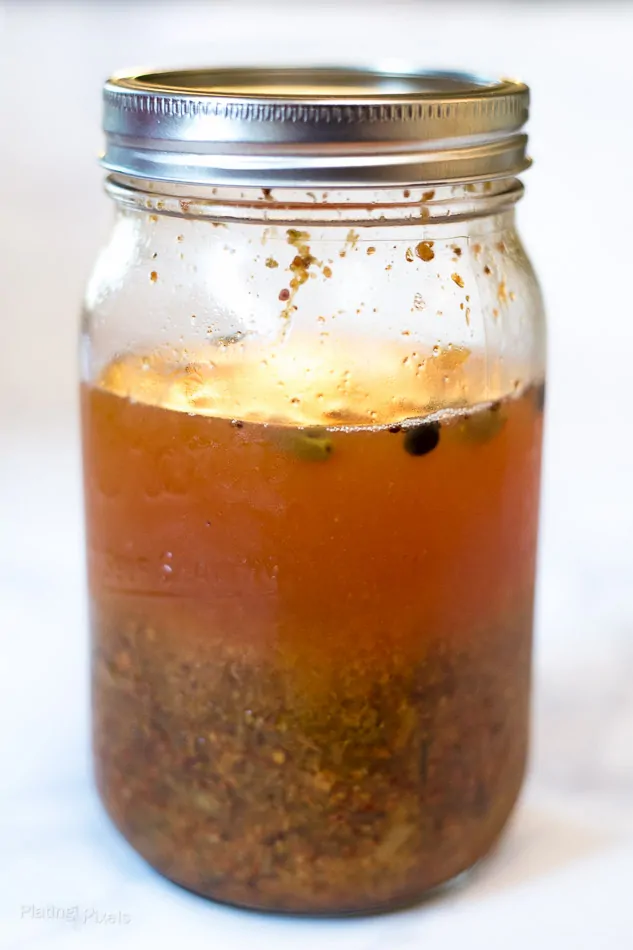 Homemade tonic water in a mason jar before straining out infused ingredients - How to Make Tonic Water