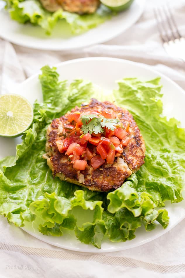 A close up of a Tuna Cake on a lettuce wrap topped with salsa