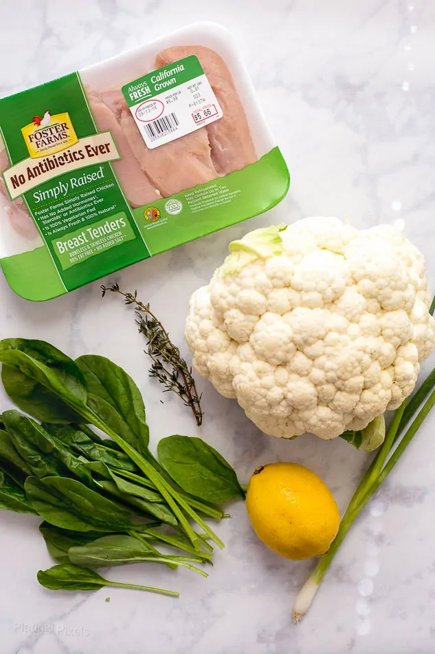 An overhead shot of ingredients needed to make lemon chicken cauliflower rice bowls