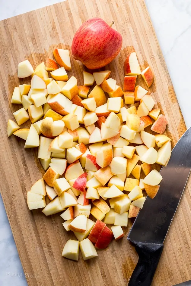 Cutting gala apple into small pieces on a cutting board