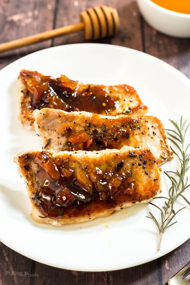 A close up of three Honey Apricot Pork Chops on a white plate
