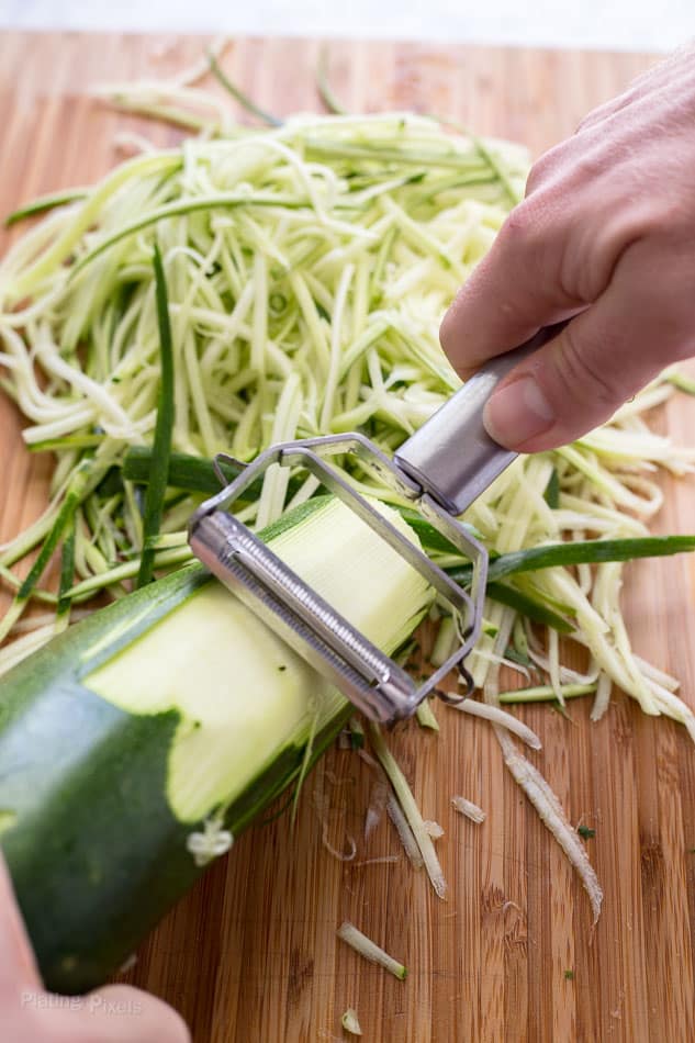 Process shot of using a shredder to make zoodles from a zucchini