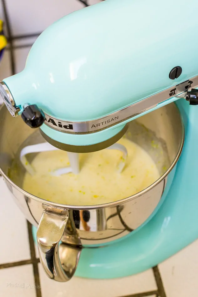 Process shot of lemon cake batter being beaten in a stand mixer