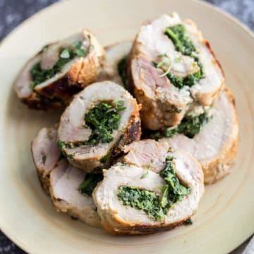 Slices of Spinach Parmesan Stuffed Pork Loin on a plate