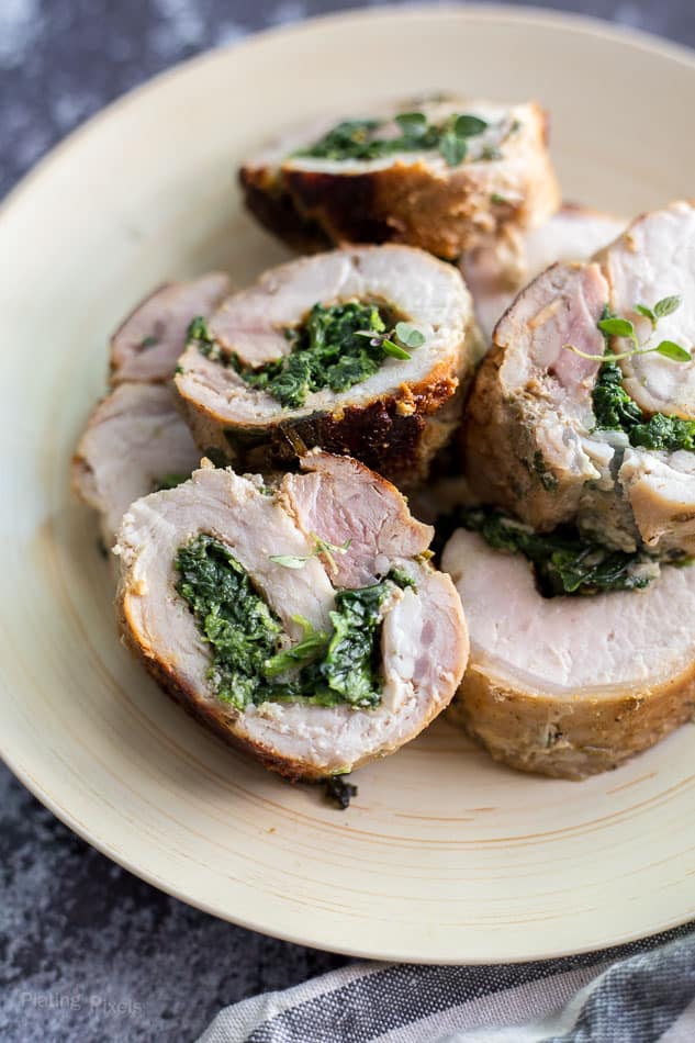 Spinach Parmesan Stuffed Pork Loin cut into slices on a plate