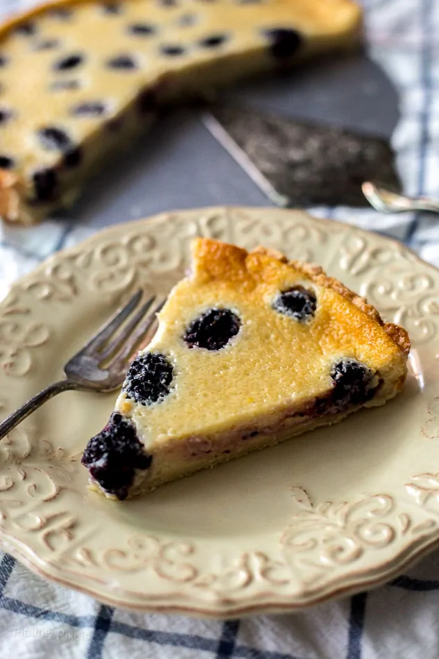 A slice of Blackberry Custard Pie on a plate with a fork