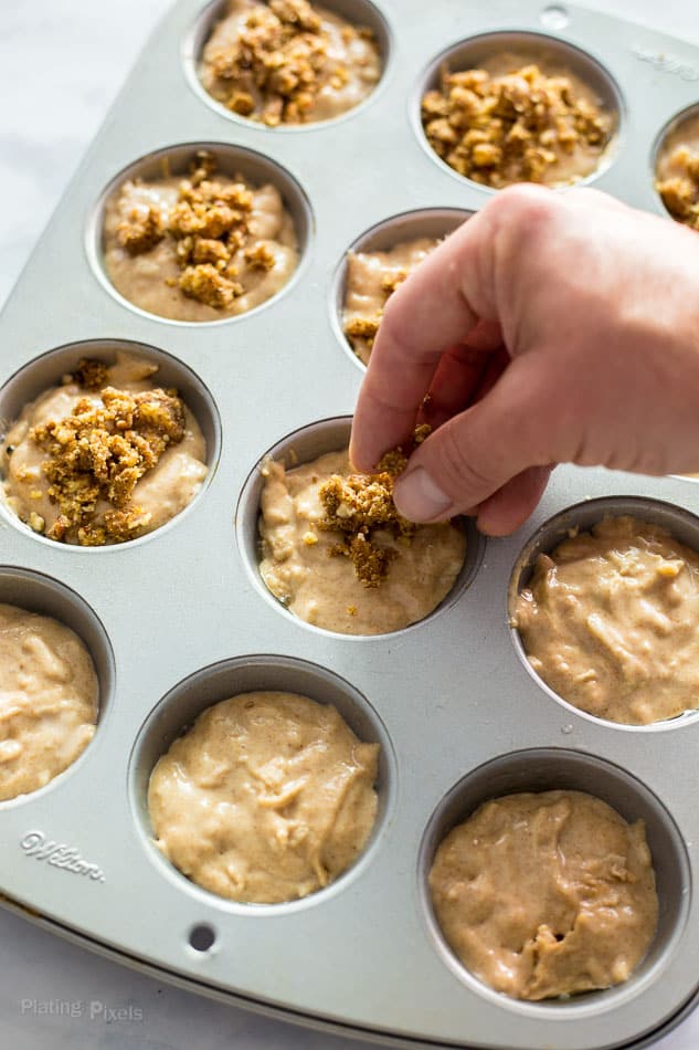 Process shot of adding crumb topping to Apple Streusel Muffin batter