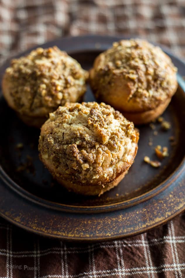 Three Apple Streusel Muffins with crumb topping on a brown plate ready to eat