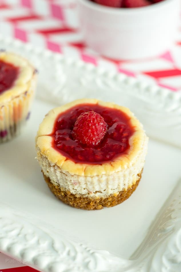 A close up of unwrapped Raspberry Mini Cheesecake muffin on a white plate
