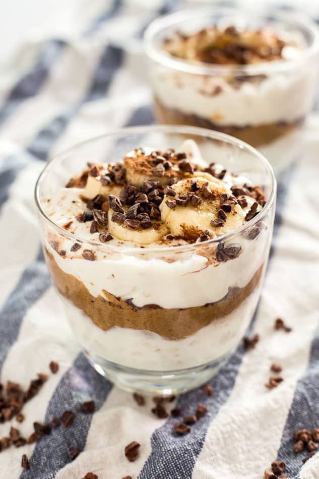 Close-up of Chocolate Almond Butter Breakfast Parfaits in glass over a striped towel backdrop