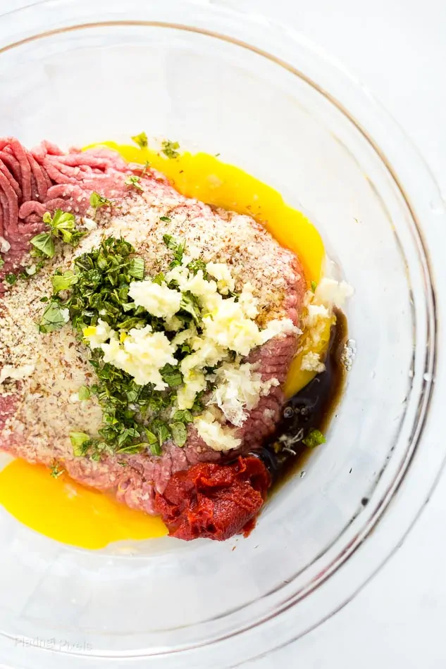 Process shot of ingredients for Sous Vide Meatloaf being mixed in glass bowl