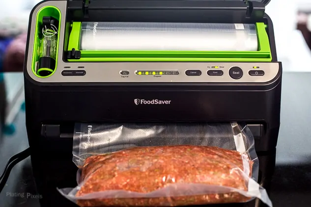 Process shot of vacuum sealing meat in plastic pouch to make Sous Vide Meatloaf