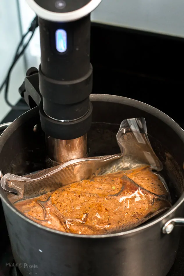 Process shot of sealed meatloaf cooking in a sous vide water bath in pot