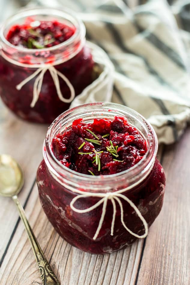 Homemade Cranberry Chutney in a glass jar topped with rosemary