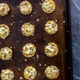 15 Mini Parmesan Spinach Phyllo Cup Appetizers on a baking sheet