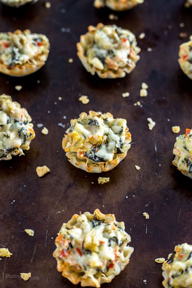 A close up of Mini Parmesan Spinach Phyllo Cup Appetizers on a baking sheet