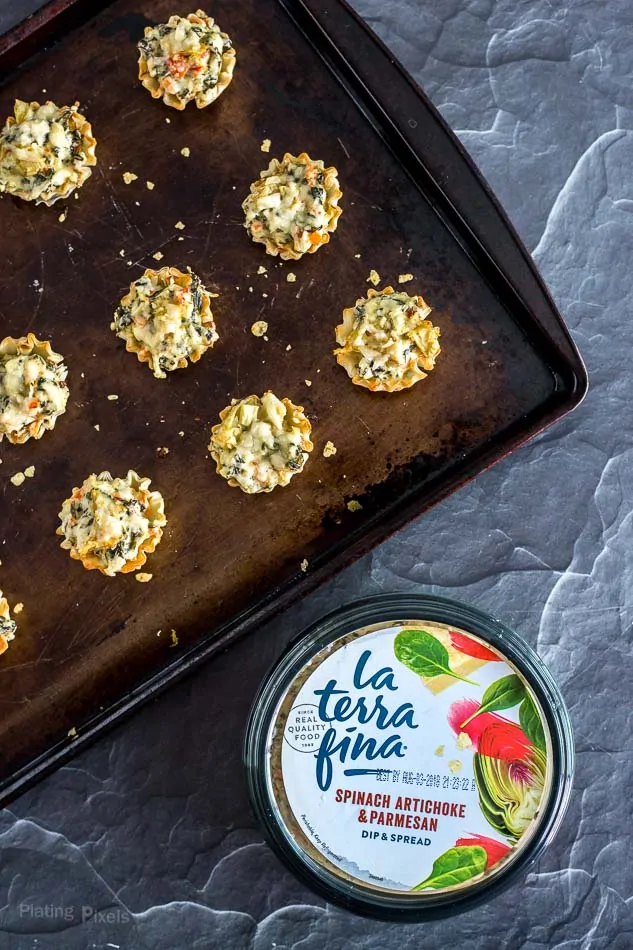 Mini Parmesan Spinach Phyllo Cup Appetizers beside a tub of spinach and artichoke dip