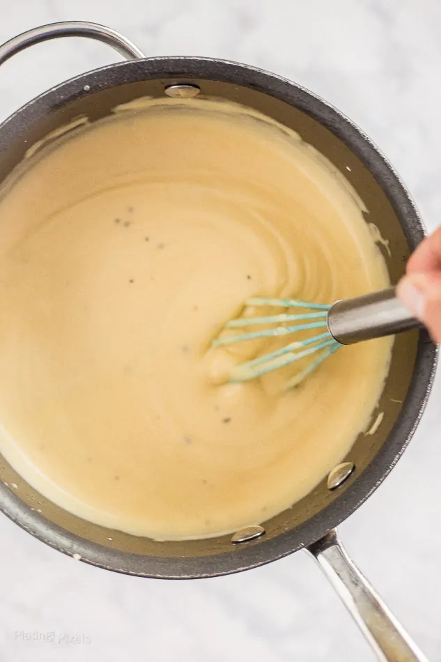 Stirring cheese sauce in a pan for Gluten-Free Mac and Cheese with Goat Cheese 