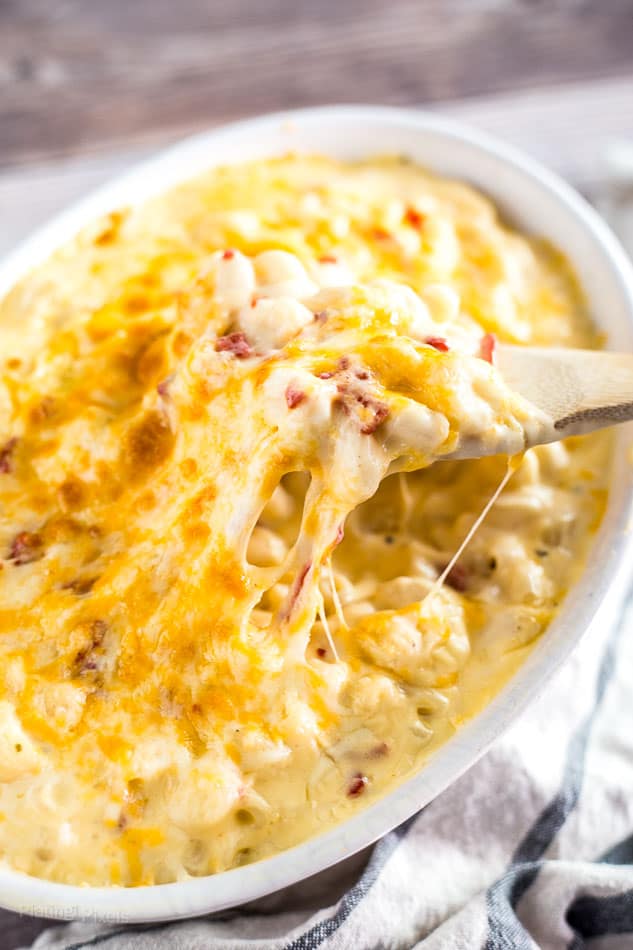 Wooden spoon scooping Gluten-Free Mac and Cheese from a casserole dish