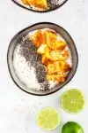 Mexican Mango with Chili and Lime Yogurt in a black bowl next to lime halves