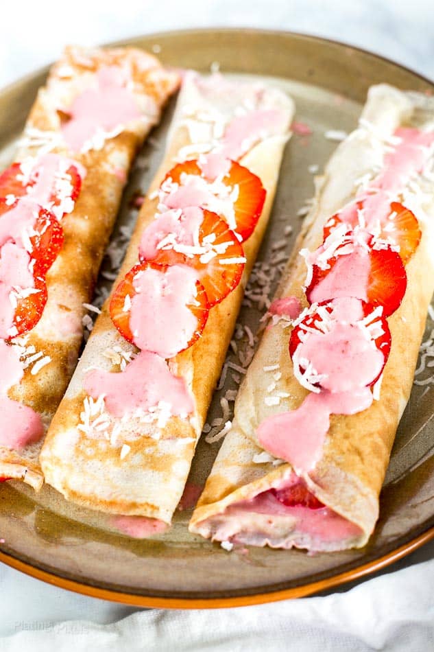 Three Breakfast Crepes with Strawberry Coconut Sauce on a plate
