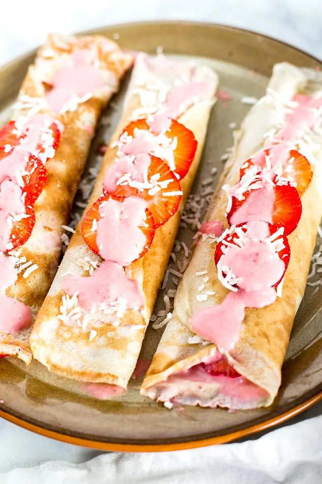 Three Dairy Free Crepes with Strawberry Coconut Sauce on a plate