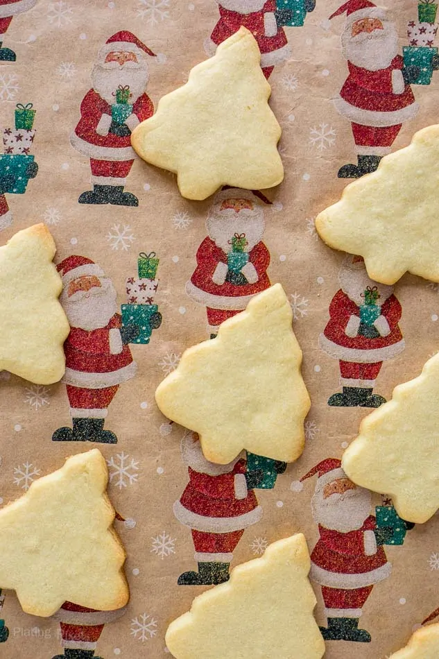 Baked Sugar Cookies over a Santa Claus decorated paper backdrop