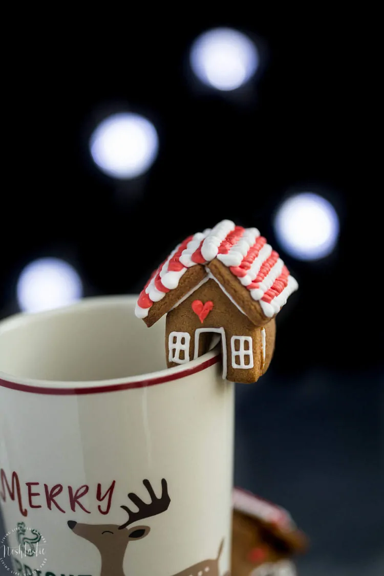 Mini decorated Gingerbread House cookie topper on edge of coffee mug