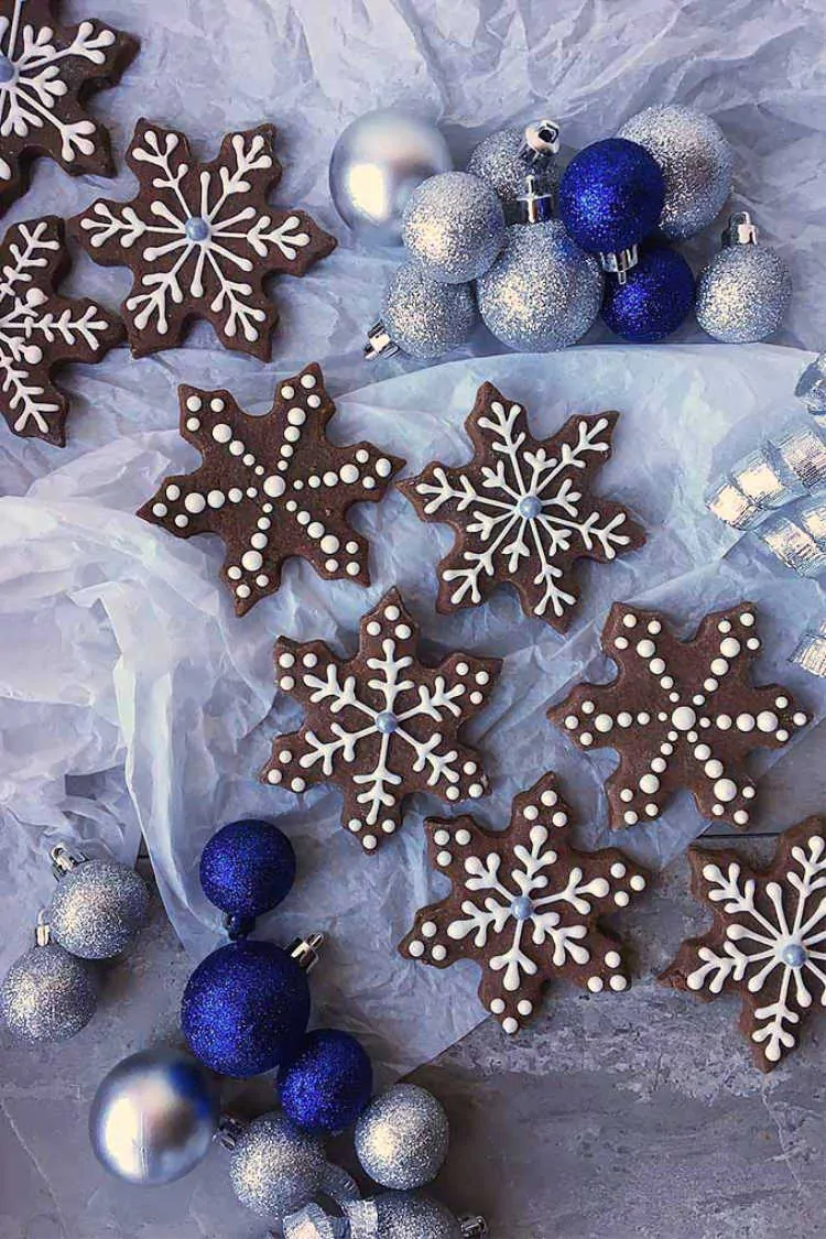 Overhead shot of Brownie Snowflake Cutout Cookies next to elegant ornaments